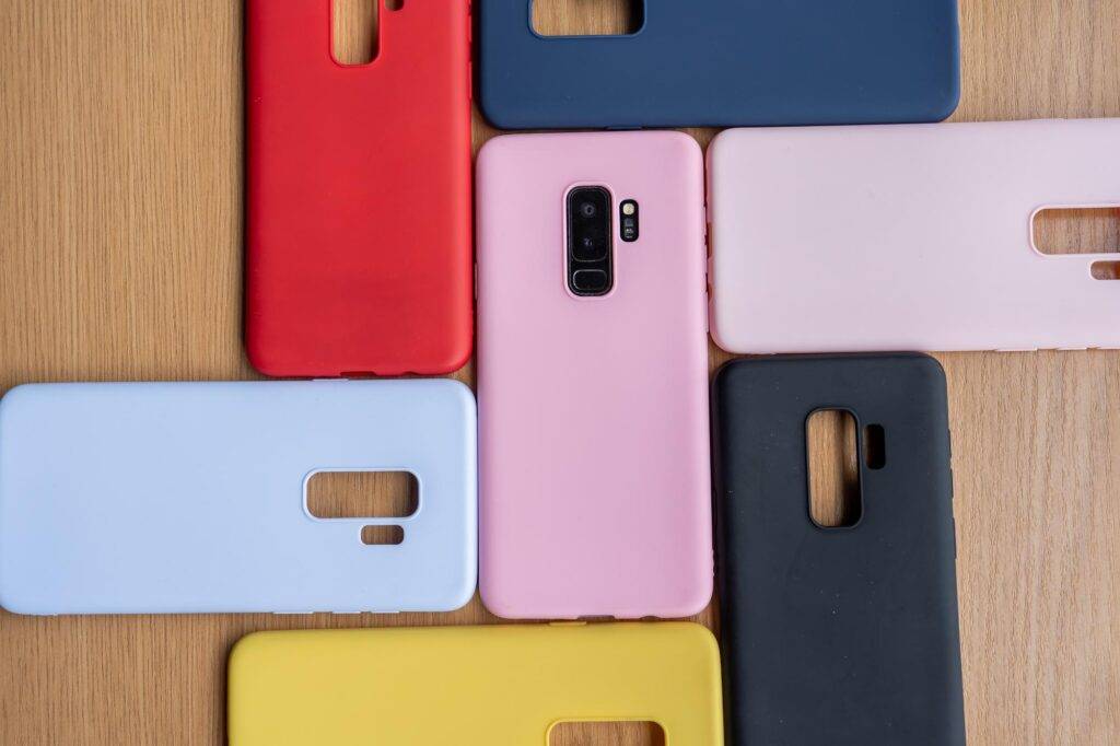 high angle shot cellphone colorful protective cases wooden surface 665346 171634